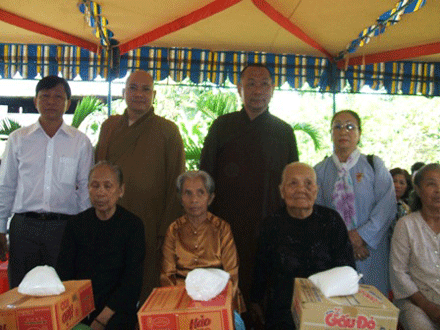phật tử Lệ Quang (bên phải) cùng thượng toa, chính quyền địa phương trao quà cho người nghèo.