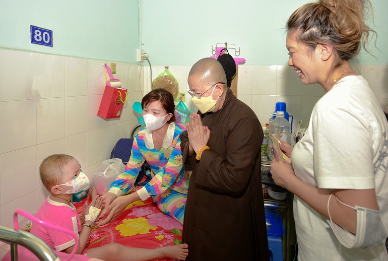 Một em bé chắp tay niệm Phật cám ơn món quà của Sư cô Thích nữ Thánh Châu và phái đoàn