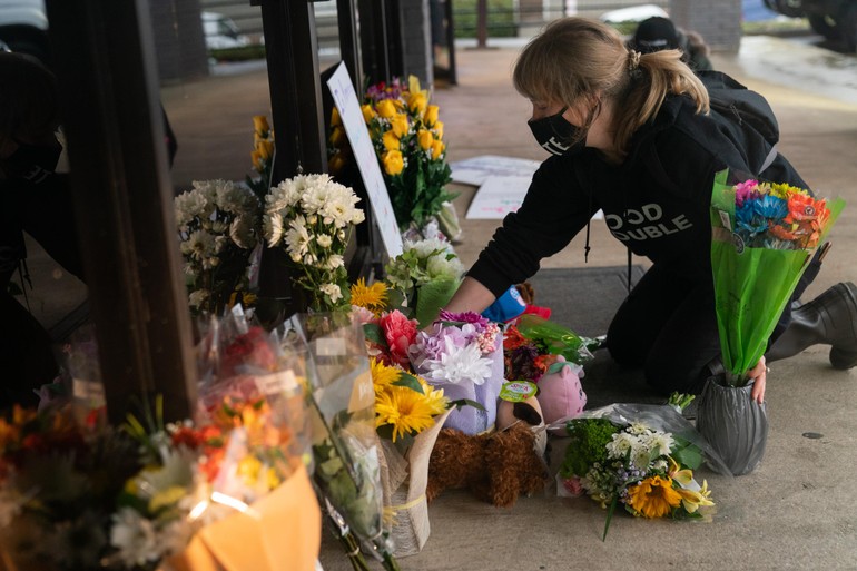 Một phụ nữ đặt hoa tưởng niệm 8 phụ nữ gốc Á bị sát hại ở Atlanta - Ảnh: Getty Images