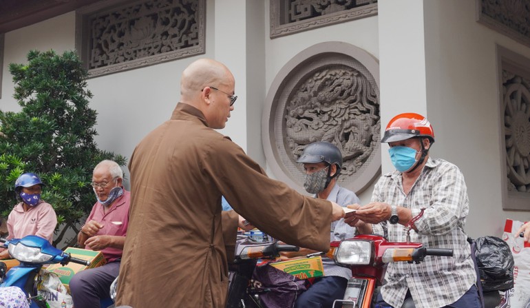 Đại đức Thích Minh Đạo, trụ trì chùa Nam Thiên Nhất Trụ trao quà đến người dân lao động khó khăn