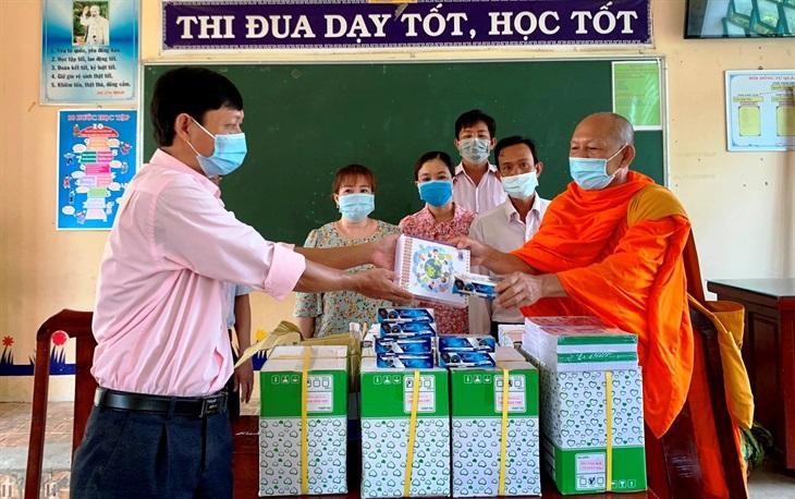Đại diện Trường Tiểu học 2, xã Định Hòa tiếp nhận quà cho học sinh khó khăn của trường - Ảnh: CTV