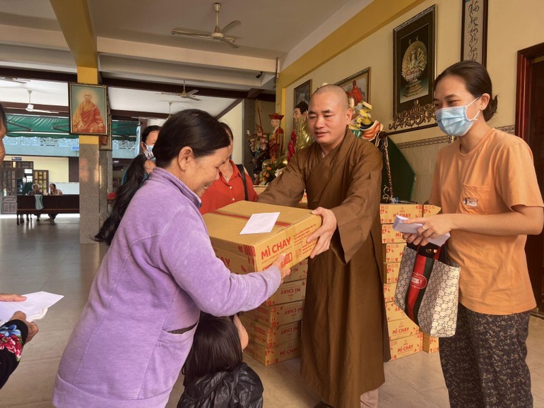 Đại đức Thích An Quang, trụ trì chùa Minh Hiệp trao quà đến những hộ khó khăn tại địa phương