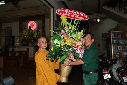 Đại tá Vũ Cao Quân tặng hoa chúc mừng Đại đức Thích Minh Thông – Trụ trì chùa Phật học thành phố Cần Thơ nhân Đại lễ Phật Đản 2010