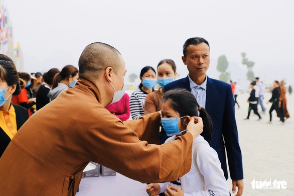 TT.Thích Minh Quang tặng khẩu trang cho người đi lễ chùa - Ảnh: Tuổi Trẻ